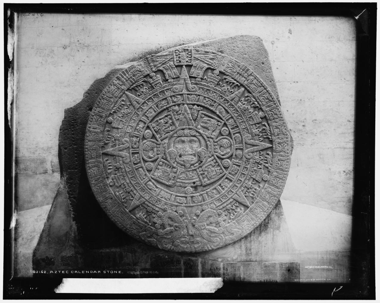 Black and white photo of a circular, intricately carved ancient stone