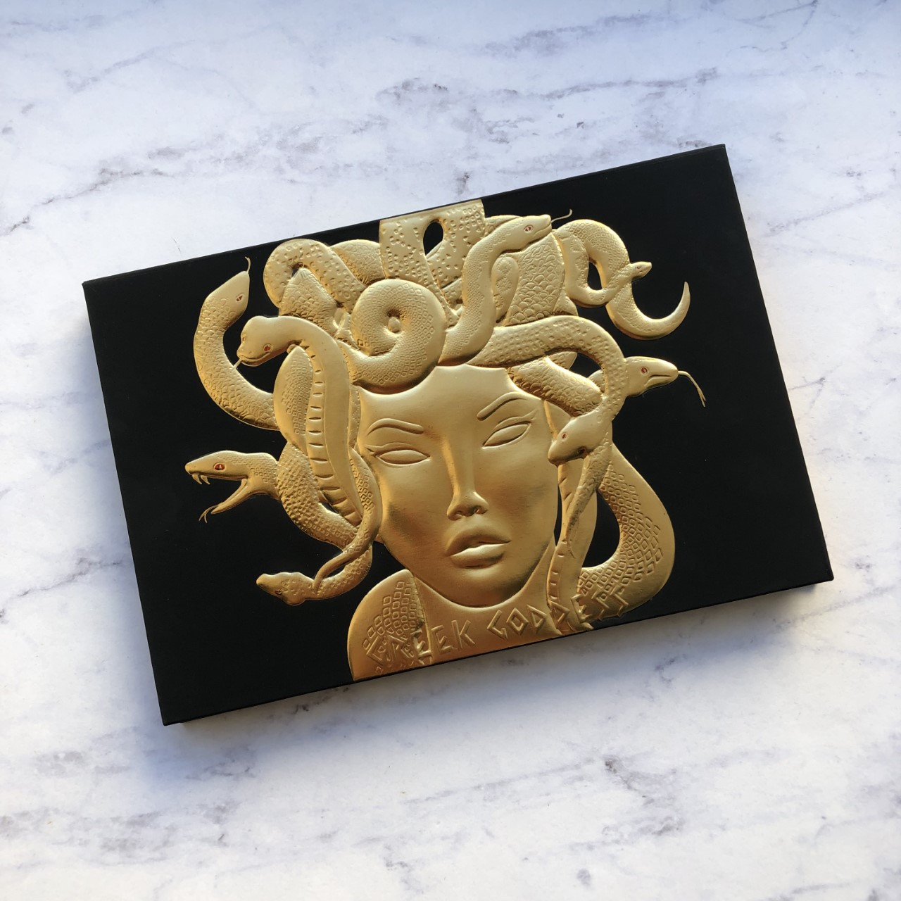 Black rectangular palette with illustration of Medusa in gold